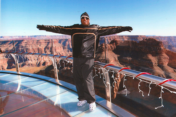 a man standing on a lookout over the grand canyon